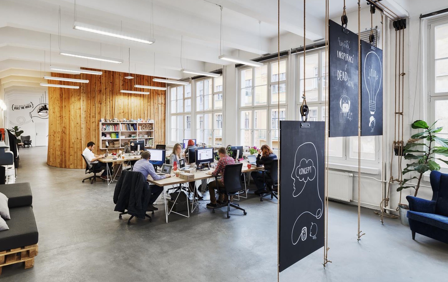 A photo of an open office with a group of coworkers sitting down at their computers.